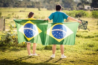 ブラジルの国旗を持って仲良く並ぶ男女の恋人たち