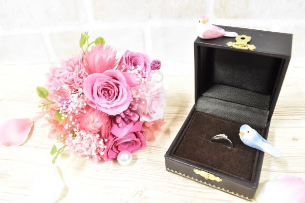 ピンクのバラの花束と結婚指輪