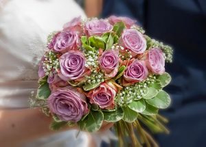 パープルのバラのウエディングブーケを持つ花嫁