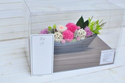 お供え札を付けたピンクと白色の花びらのアレンジメントの画像