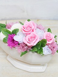 淡いピンク色のバラが白い陶器の器に入ったアレンジメント