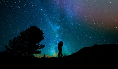 夜空を背景に抱き合う男女のカップル