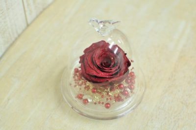 ガラスドームの中に赤く大輪のバラが入ったアレンジメント