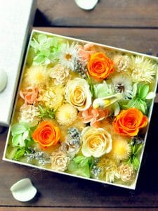 正方形のボックスにイエロー・オレンジ・グリーンのお花が敷き詰められたもの
