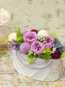 白い花器に紫色の花のアレジメント